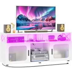 an entertainment center with speakers and a large television on top of it, in front of a white background