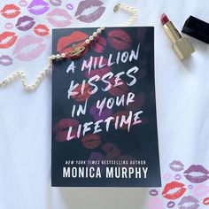 there is a book with lipstick on it and a necklace next to the book cover