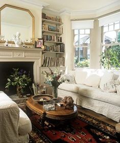 a living room filled with furniture and a fire place in front of a large window