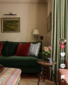 a living room with green couches and colorful pillows on the floor, along with other furniture