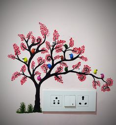 an electrical outlet is decorated with pink flowers and birds on a tree painted on the wall