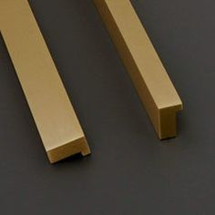 two gold handles on a gray surface