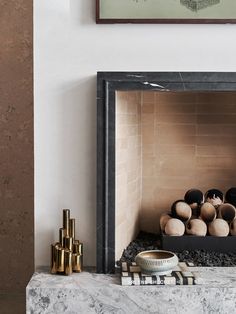 a fire place with candles and vases on the mantle in front of a painting