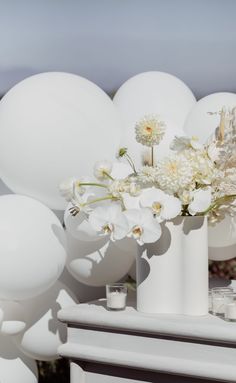 white flowers and balloons are on the table