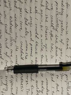 an ink pen sitting on top of a piece of paper with cursive writing