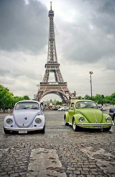 two cars parked in front of the eiffel tower