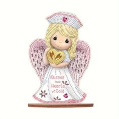 an angel figurine holding a heart with the words nurses love hearts of gold on it