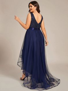 a woman in a long blue dress pointing at something