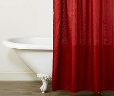 a red shower curtain hanging in front of a bathtub