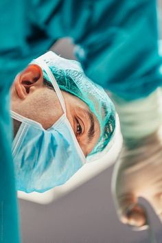 a man in scrubs is looking at the camera