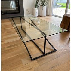 a glass table sitting on top of a hard wood floor next to a fire place