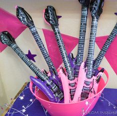 a pink bowl filled with musical instruments on top of a table