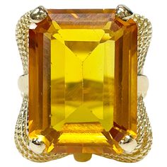 14 Karat Yellow Gold Citrine Cocktail Ring. The ring features an emerald cut 20 x 15mm prong-set golden Citrine. There are twisted wire scroll-like designs adorning all sides of the Citrine and the split band. The Citrine stone has light wear however it's in overall good condition. The ring size is 7 1/4 and has a gold weight of 18.47 grams. Luxury Fine Jewelry Citrine Crystal Ring, Luxury Yellow Citrine Rings, Yellow Gold Cocktail Ring, Gold Cocktail Ring, Gold Cocktail, Twisted Wire, Citrine Ring, Citrine Stone, Chanel Paris