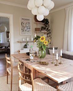 a dining room table with sunflowers and wine glasses on it's centerpiece