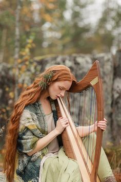 a woman with long red hair playing a harp