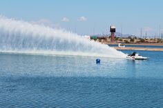 a jet ski being pulled by a boat in the water with a large plume of water behind it