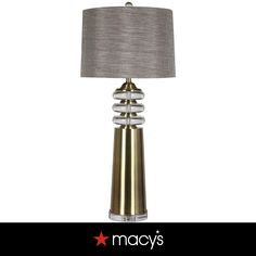 a lamp that is sitting on top of a table next to a white wall with the words macy's written below it