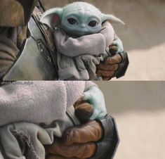 the baby yoda doll is held by someone's arm and wearing a blanket