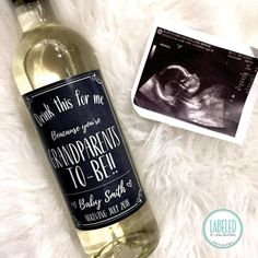 a bottle of wine sitting on top of a white blanket next to an old photo