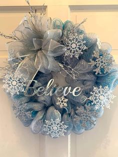 a wreath with the words believe and snowflakes hanging from it's front door