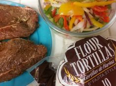 there is a bowl of salad and some meat on the plate next to each other