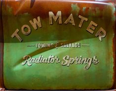 an old sign advertising tow matere towing and salvage, with rusted metal lettering