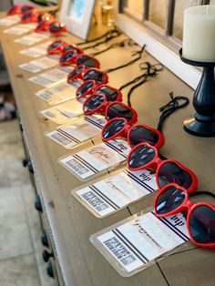 several pairs of red sunglasses sitting on top of a table