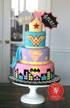 a multi - tiered cake decorated with batman and wonder symbols