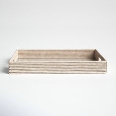 a wooden tray with holes in it on a white surface, the bottom half is empty