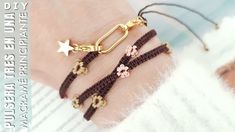 three bracelets with flowers and stars on the wrist, one has a gold chain