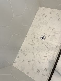 a shower with white marble walls and floor