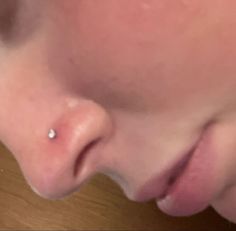 a close up of a person's nose with a piercing in the middle of it