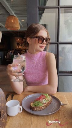 a woman sitting at a table with a plate of food