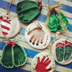 four handprinted ornaments are hanging on a table