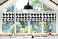 an open kitchen window with black and white checkered blind in the windows above it