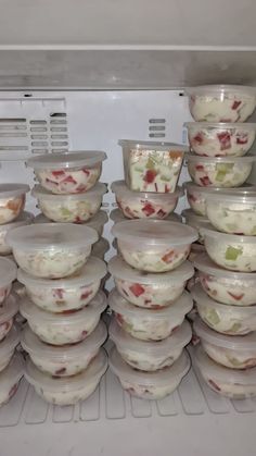 there are many plastic containers stacked on top of each other in the refrigerator, and one is filled with food