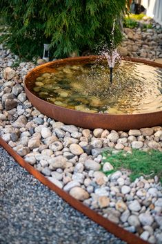 a water fountain surrounded by rocks and gravel