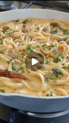 a pan filled with pasta and bacon on top of a stove