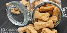 a glass jar filled with dog treats on top of a wooden table