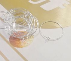 a pair of silver hoop earrings sitting on top of a table