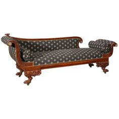 an ornately carved wooden couch with black and white fabric on it's back