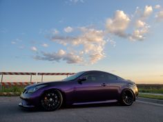 a purple sports car parked on the side of the road