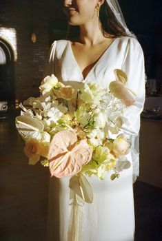 a woman in a white dress holding a bouquet of flowers