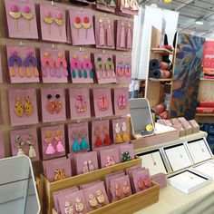 there are many earrings on display in the store, and it's pink color