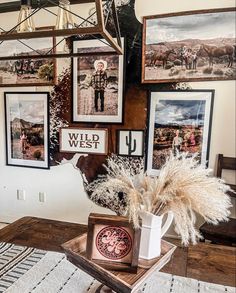 a living room with pictures on the wall and a coffee table in front of it