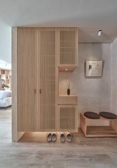 a room that has some shoes on the floor and shelves in front of it with wooden slats