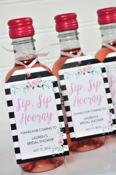 three bottles of sip sip hooray with pink flowers and black stripes on them