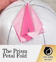 an origami bird on top of a white ball with the words, the prism petal fold