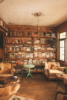 a living room filled with furniture and bookshelves covered in lots of bookcases