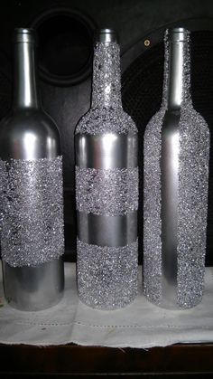 three bottles with silver glitter on them sitting next to each other